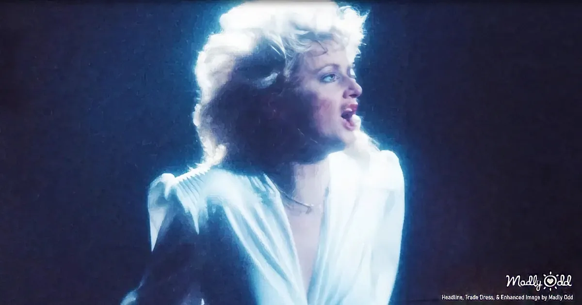 A person in a white shirt with a dramatic, intense expression, illuminated by blue light against a dark background.