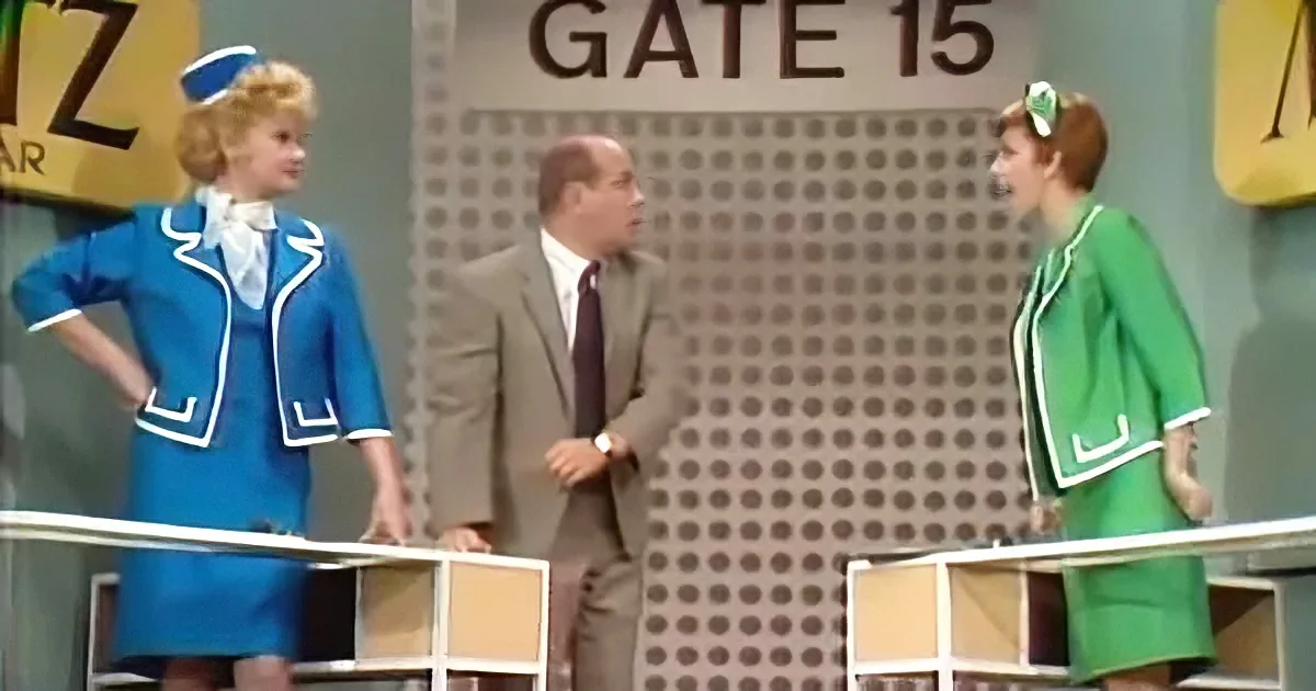 A man in a suit stands between two women in flight attendant uniforms, one in blue, the other in green, with a "GATE 15"...