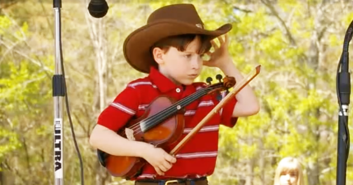 Fiddle Competition at the County Fair - Boy in Cowboy hat with fiddle adjusting cowboy hat