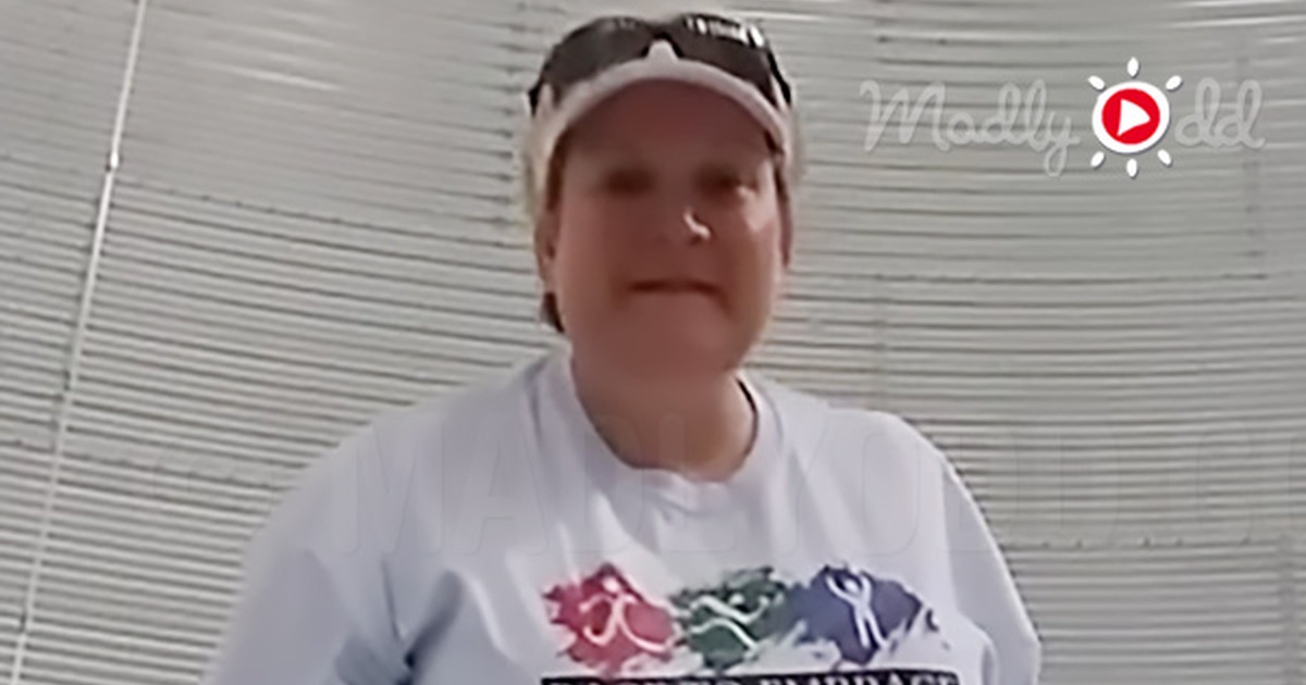 A woman in a white t-shirt stands against a corrugated metal wall, with text overlay about her singing performance.