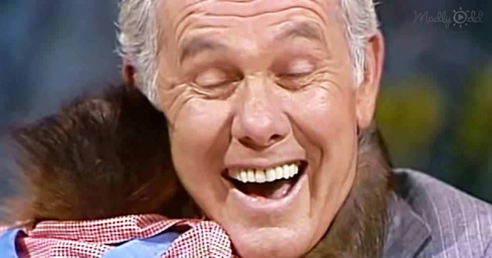 Johnny Carson gets a hug from a baby orangutan
