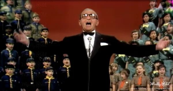 Irving Berlin, an 80-year-old man, stands center stage on The Ed Sullivan Show, illuminated by soft studio lighting. His face is full of emotion as he sings 'God Bless America,' forming a reverent backdrop.