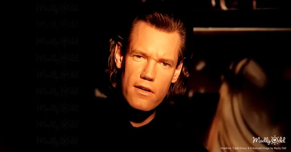 A dimly lit room with an old wooden box on a dresser, surrounded by faded photographs, a pocket knife, and a worn wallet. A man stands over the box, gently lifting one of the old photographs, his face reflecting bittersweet memories.