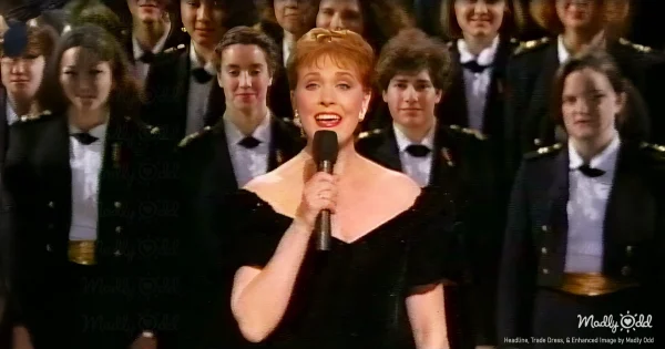 Julie Andrews elegant black evening gown National Building Museum 1992 Christmas special stage lights warm glow. Classical architecture interior ornate columns dramatic lighting crystalline soprano performing holiday carols dignified pose.